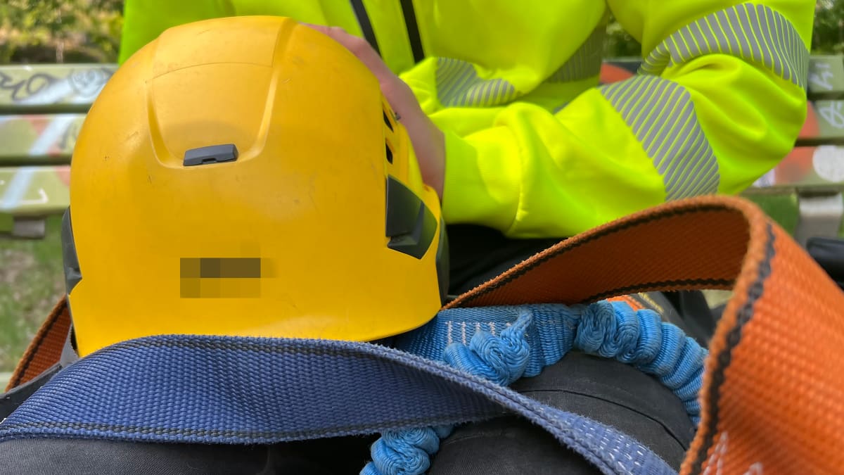 Një person me veshje të vëmendjes i ulur në një stol.