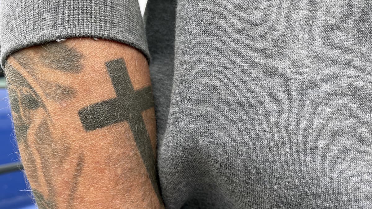 Risti-tatuointi käsivarressa.