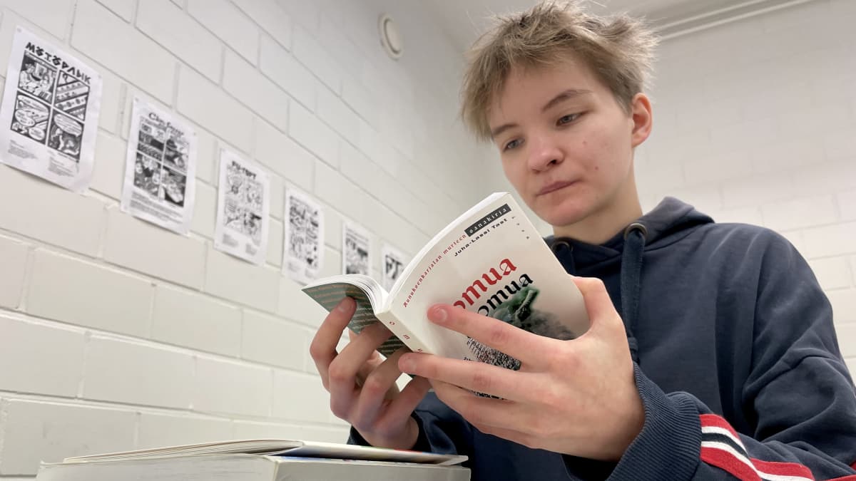 Nuori, lyhythiuksinen nainen lukee karjalan kielen sanakirjaa.