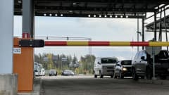 Raja-aseman puomi Vaalimalla Virolahdella, taustalla näkyy autoja ja linja-autoja jonottamassa kohti Suomea.