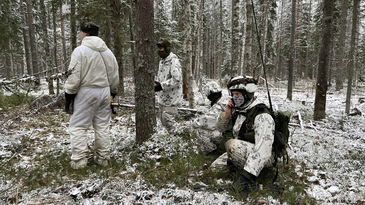 Kolme varusmiestä lumipuvuissa keskellä lumista metsää Kontio 22 -pääsotaharjoituksessa Nurmeksen Sotinpurolla.