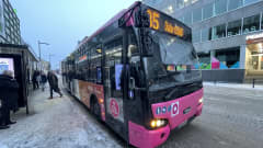Pinkki bussi bussipysäkillä.