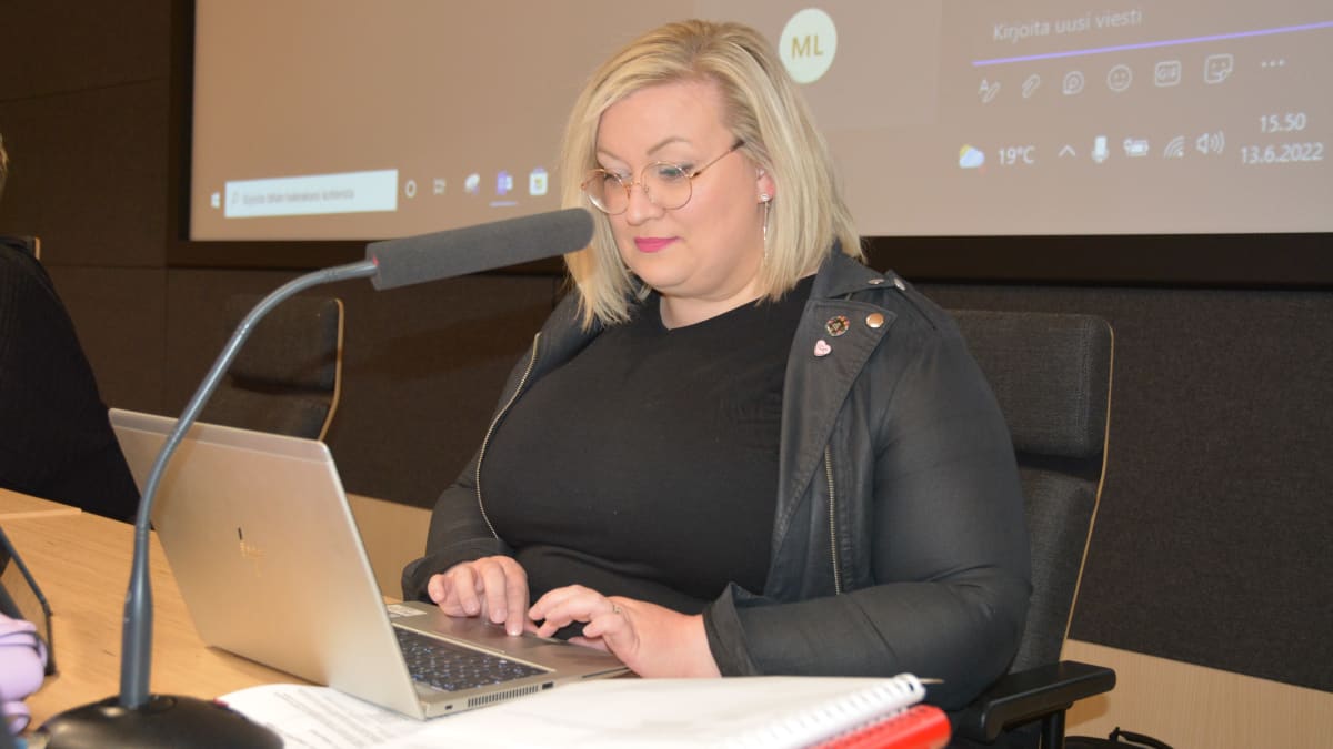 Tiina Isotalus istuu puheenjohtajan paikalla Kokkolan valtuuston kokoussalissa. Hän tutkii tietokonettaan kokouksen alussa.