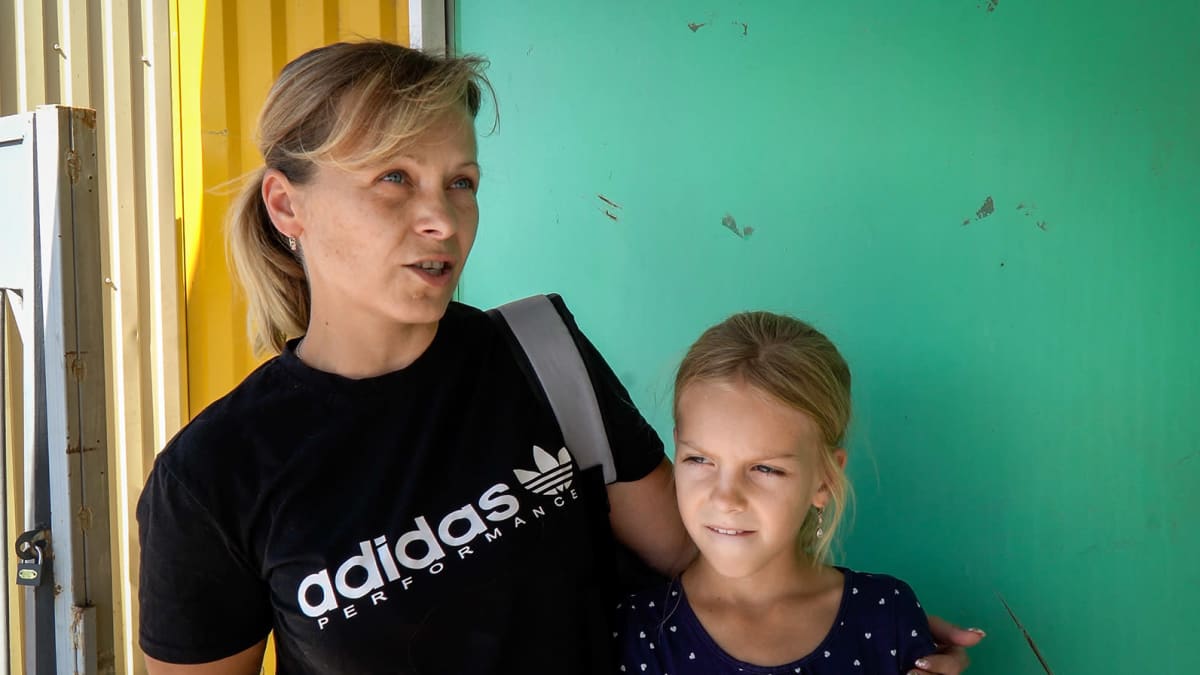 Ludmila ja hänen lapsensa seisovat kameran edessä kun heitä haastatellaan. 