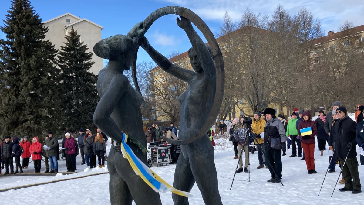 Ihmisiä lumisessa Kiovanpuistossa Tampereella osoittamassa myötätuntoa Ukrainalle. 