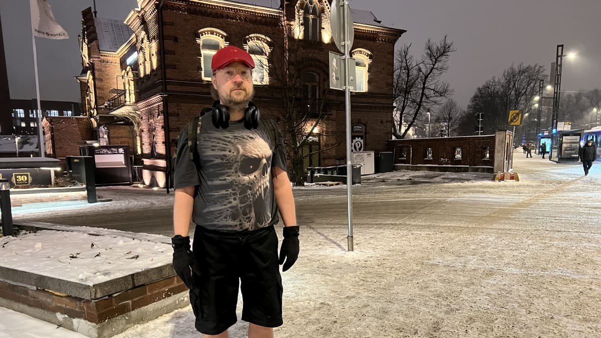 Jari Laakso seisoo Tampereen keskustassa marraskuisessa aamuhämärässä. Yllään hänellä on t-paita ja shortsit.