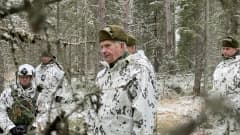 Maastopukuinen Sauli Niinistö alkutalven metsässä.