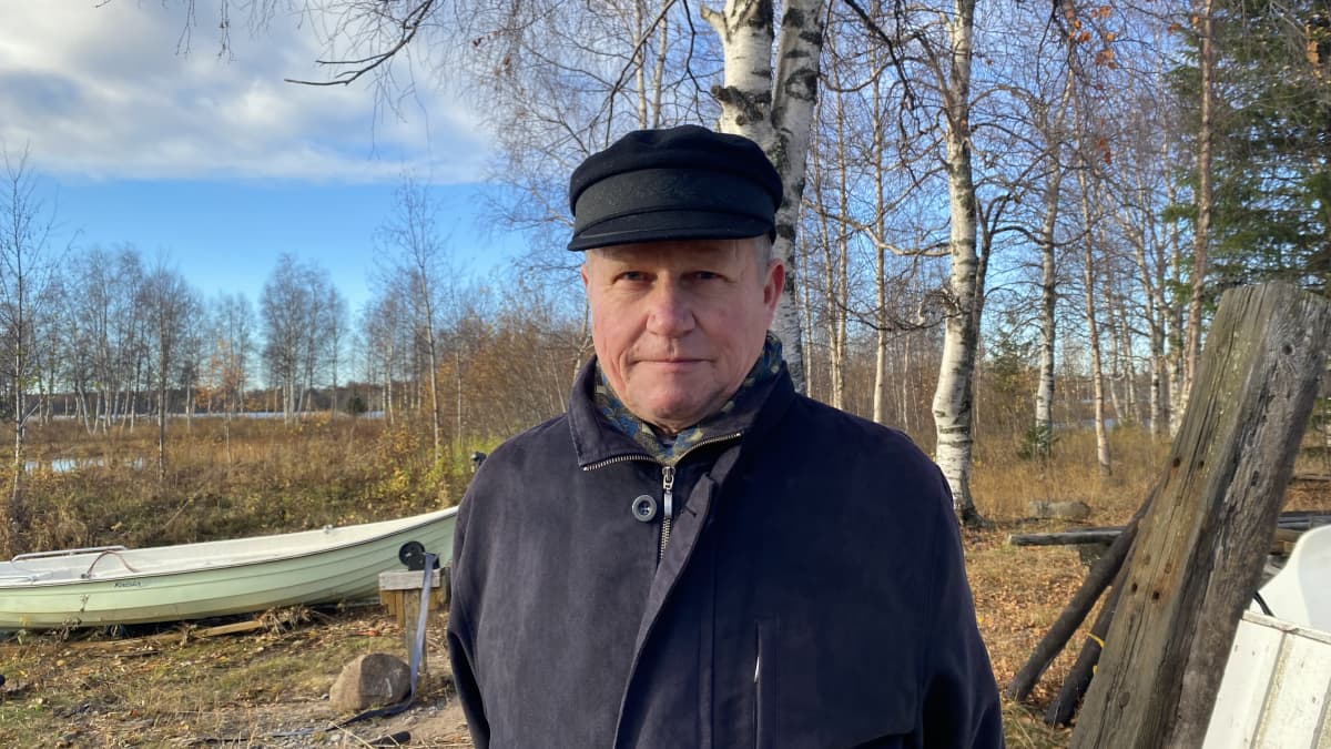 Juha Ylimaunu, yksi Perämeren historiaa esittelevän kirjan kirjoittajista, seisoo Perämeren rannalla Kemin Kalkkinokalla. Taustalla näkyy vene ja kaukana pilkottaa meri.