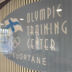 Kyltti Kuortaneen urheiluopiston seinässä. Siinä lukee Olympic Training Center Kuortane. 