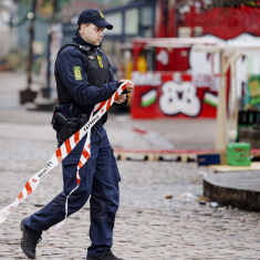 En polis i uniform spärrar av Pusher street i Christiania. 