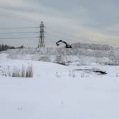Kaivuri lumikasan päällä Oulun Oritkarissa