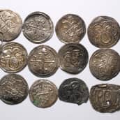 Viikinnkiaikaisia hopeakolikoita siisteissä riveissä. 