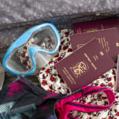 Avonaisessa matkalaukussa on snorkkeli, uimapuku, neljä passia ja mekko. 