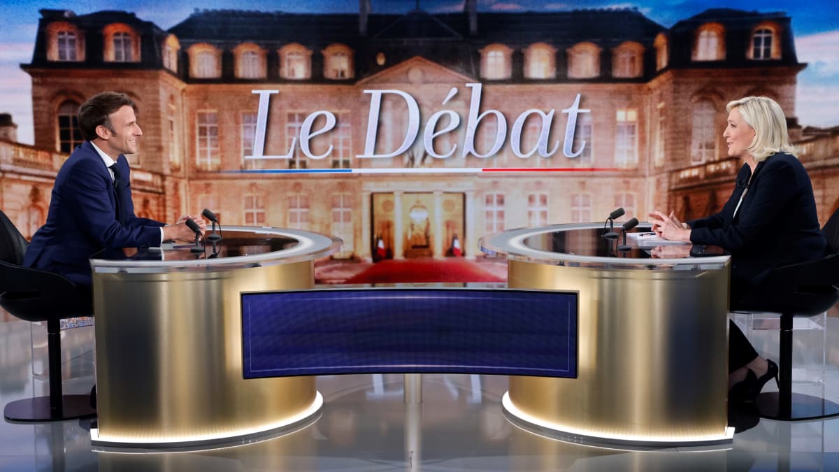 Ranskan presidentti Emmanuel Macron ja presidenttiehdokas Marine Le Pen istuvat vastakkain vaaliväittelyssä.