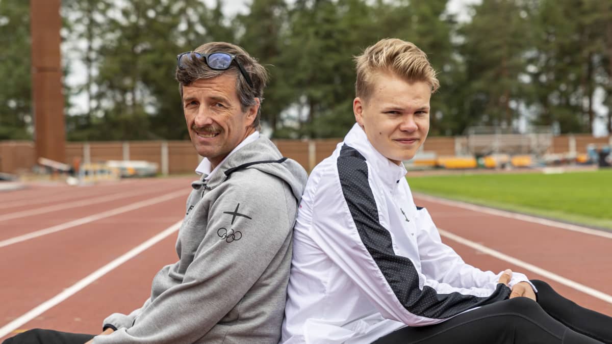 Eemil Helander istuu Harjun stadionin juoksuradalla yhdessä valmentajansa Ari Nummelan kanssa