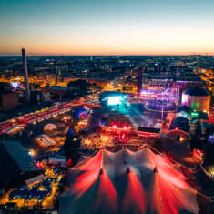 Nighttime aerial photo of Helsinki's Flow Festival in 2022, featuring brightly coloured tents and stages.