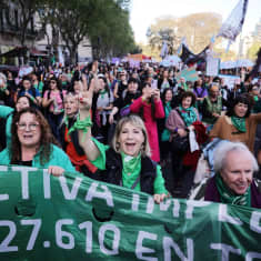 Argentiinalaisia naisia osoittamassa mieltään kaduilla, kuvan etualalla naiset pitelevät banderollia.