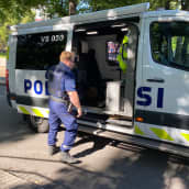 Poliisi sulkemassa poliisiauton liukuovea 
