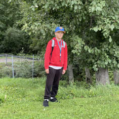 13-vuotias pesäpallon harrastaja Jesse Soininen seisoo nurmialueella ison puun vierellä.
