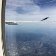 Lentokoneen ikkunasta näkyy Finnairin siipi ja joki sekä peltoja.