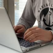 Mies kirjoittaa koneen äärellä.