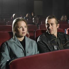 Photo shows a scene from Fallen Leaves, with the two protagonists sitting in a cinema.