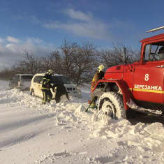 Tietä raivataan yön lumisateen seurauksena Mykolaivin alueella Ukrainassa.