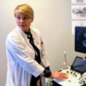 Professori Terhi Piltonen käyttää ultraäänitutkimuslaitetta