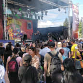 Wanaja Festivalin yleisö pakkautuneena lavan eteen kuuntelemaan Klamydiaa aurinkoisena kesäpäivänä.