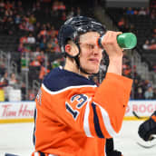 Jesse Puljujärvi puristaa vettä naamaansa juomapullosta.