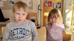 5-vuotias Eino Lepola ja 3-vuotias Anni Tenkanen istuvat luokkahuoneen pöydän ääressä. Aurinko paistaa kevyesti sisään ikkunasta.
