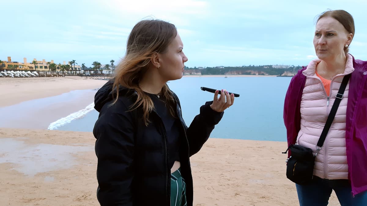 Milja ja Kati puhuvat puhelimeen portugalilaisella rannalla.