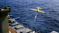 En gul drönare avfyras från ett fartyg.