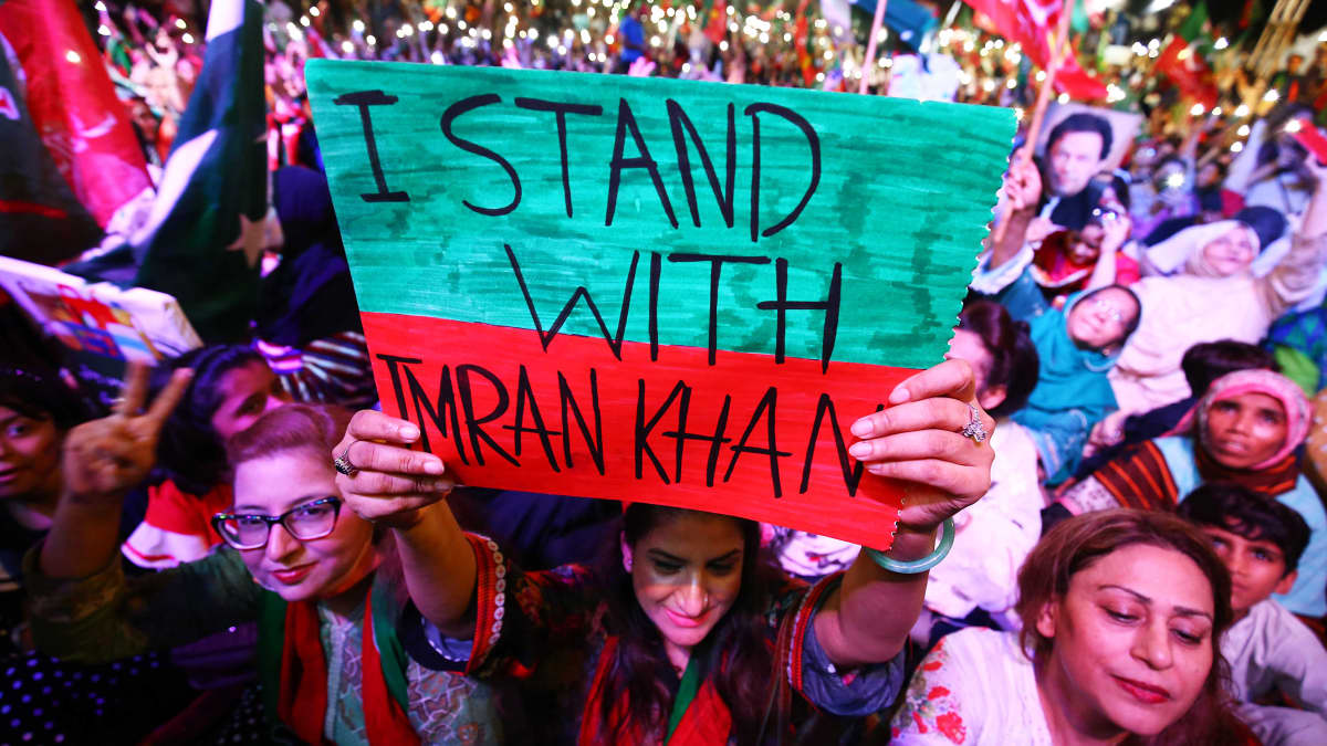 Ihminen nostaa kylttiä mielenosoituksessa. Kyltissä lukee "I stand with Imran Khan", eli minä tuen Imran Khania.