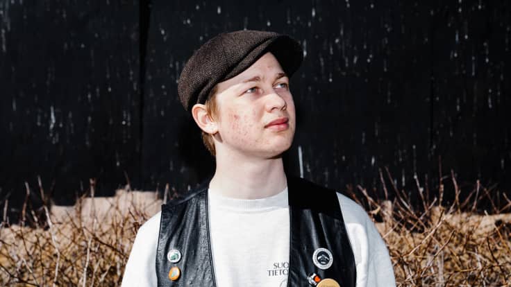 Vili Nurmi seisoo ulkona työmaa-aidan edessä.