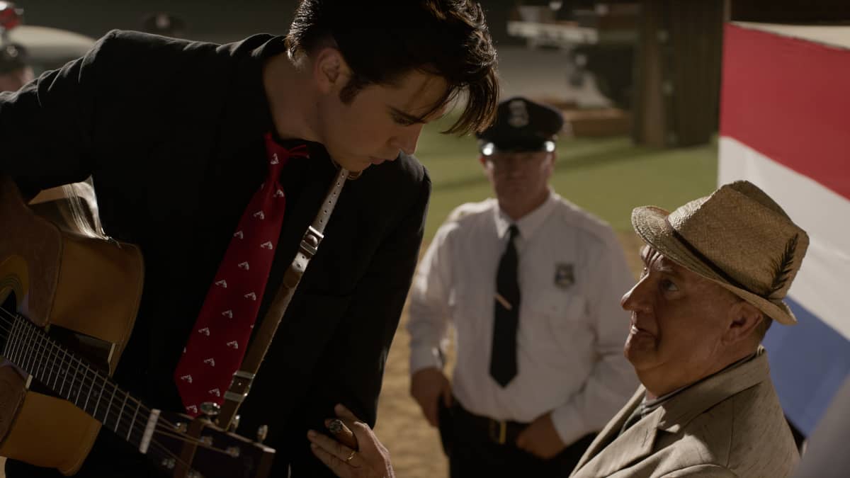 Austin Butlerin näyttelemä Elvis pitelee kitaraa, vieressä manageri, eversti Parker, jota näyttelee Tom Hanks.