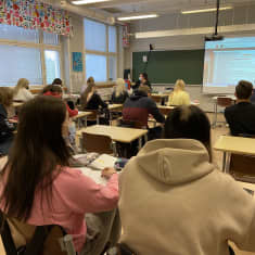 Lukiolaiset istuvat pulpeteissa oppitunnilla.