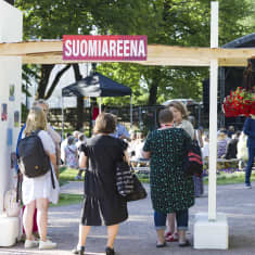 Naisia seisoo Suomiareena-kyltin alla.