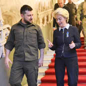 Ukrainan presidentti Volodymyr Zelenskyi ja EU-komission puheenjohtaja Ursula von der Leyen kävelevät alas portaita ja keskustelevat.