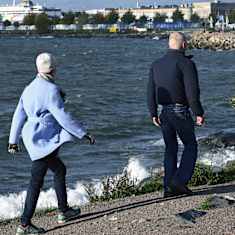 Ulkoilijoita auringossa ja tuulessa Helsingin Eiranrannassa.