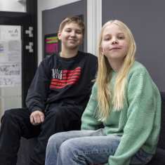 Keljonkankaan yhtenäiskoulun oppilaat Eemeli Könönen ja Verna Lehtonen istuskelevat koulun käytävällä.