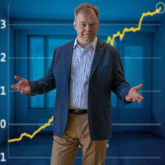 Svenska Yle:s redaktör Patrik Schauman står framför en uppåtsträvande ekonomisk kurva. 