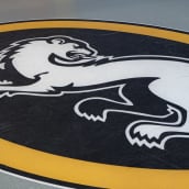 Jääkiekkojoukkue Oulun Kärppien logo, jossa valkoinen kärppä mustalla taustalla ja keltaisella kehyksellä.