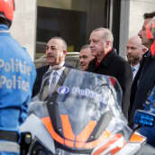Turkin ulkoministeri ja presidentti kävelevät poliisirivistön ohi Brysselissä.