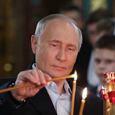 Venäjän presidentti Vladimir Putin sytyttää tuohusta kirkossa.