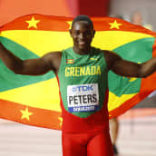 Anderson Peters håller upp Grenadas flagga bakom sig.