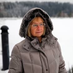 Atopiaa sairastava lahtelainen Anja Kontto on kuvassa ulkona Vesijärven rannassa. Luminen maisema ja Anjalla paksut talvivaatteet yllään. Katsoo järvelle.