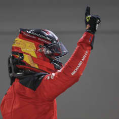 Carlos Sainz tuulettaa kypärä päässä.