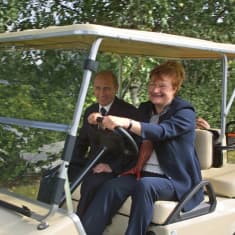Presidentti Halonen ajaa golf-autoa.