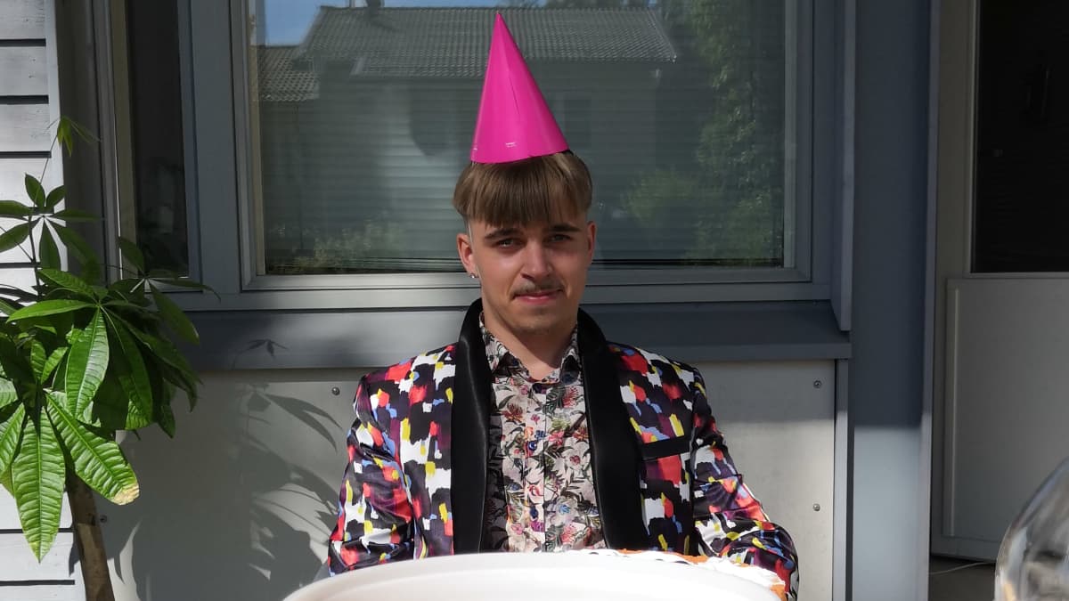 Mies istuu pöydän päässä. Pöydällä on vodkalla täytettyjä kuohuviinilaseja. 